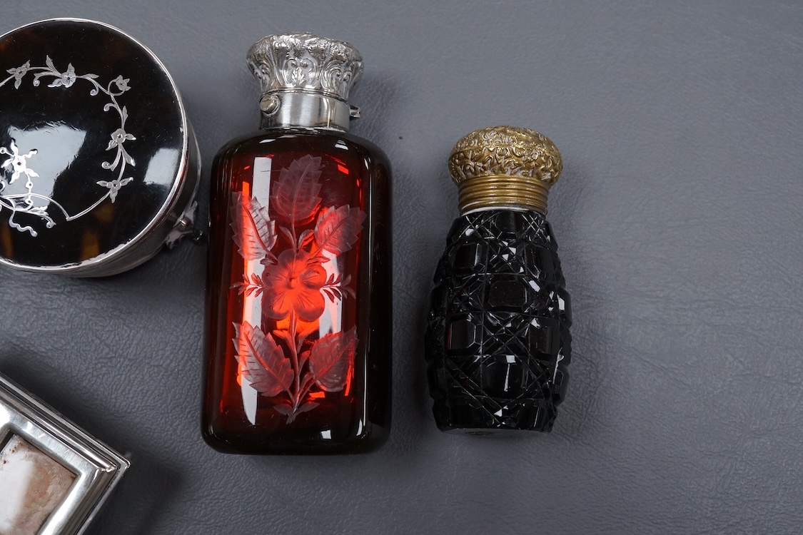 An Edwardian silver and tortoiseshell pique mounted trinket box, by William Comyns, London, 1905, diameter 59mm, together with one other George V trinket box on tripod feet, two mounted glass scent bottles, a Victorian m